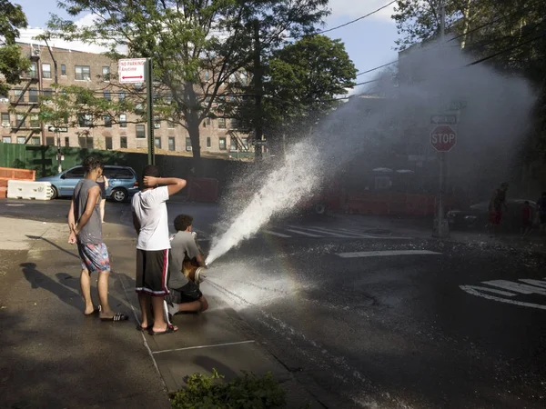 Kids play with water from open hydrand in summer — Stock Photo, Image