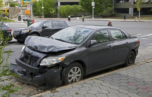 Vehicle parked on curb showing damage from a wreck — Stock Photo, Image