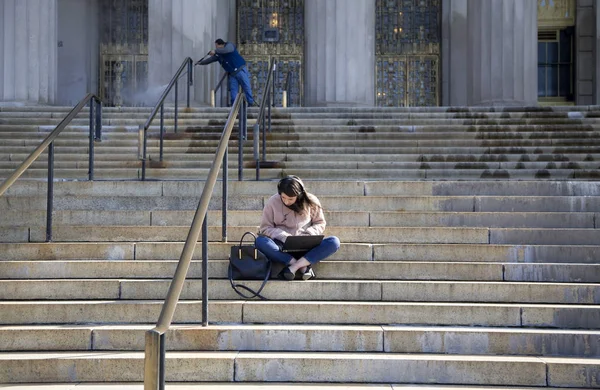 Vrouw die laptop gebruikt terwijl hij op stappen van Bronx County Courth zit — Stockfoto
