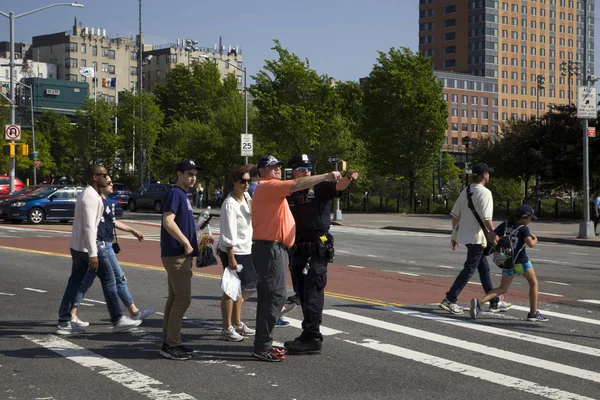 Policjant wspomaga mężczyznę ze wskazówkami po grze Yankee bro — Zdjęcie stockowe