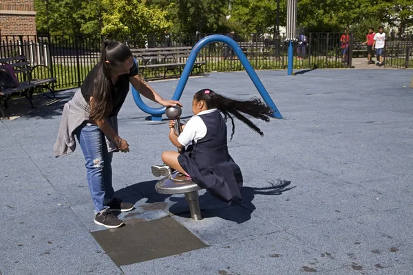 Kobieta obraca swoje dziecko na przejażdżkę Park w pobliżu stadionu Yankee Bronx N — Zdjęcie stockowe