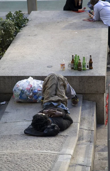 Macho negro que recoge botellas y latas para obtener ganancias descansa en fro —  Fotos de Stock