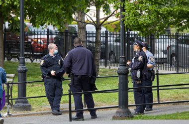 BRONX, NEW YORK / USA - 18 Mayıs 2020: NYPD okul güvenliği memurları COVID-19 salgını sırasında maskeleriyle parkın yakınındaki bir yerde.