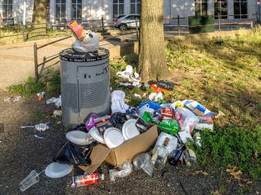 BRONX, NEW YORK/USA - August 2, 2020: Trash builds up at a public park near Yankee Stadium due to budget cuts to sanitation by Mayor Bill Deblasio.  clipart