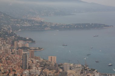 Gözlem güverteden manzaralı panorama Monaco. Çatılar evler ve binalar ve arka plan tepelerde. Yelkenli tekne ve Yat Limanı, iskele. Hava üstten görünüm, Sisli sabah. Fransa