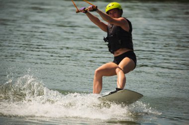 Genç kadın çalışma Wakeboarding bir göl kenarında