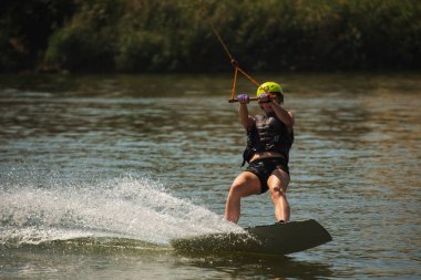 Genç kadın çalışma Wakeboarding bir göl kenarında
