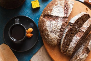 Taze ev yapımı koyu ahşap tahta ve kahve fincan dilimlenmiş beyaz un ile ekmek. Yakın çekim. Üstten görünüm.