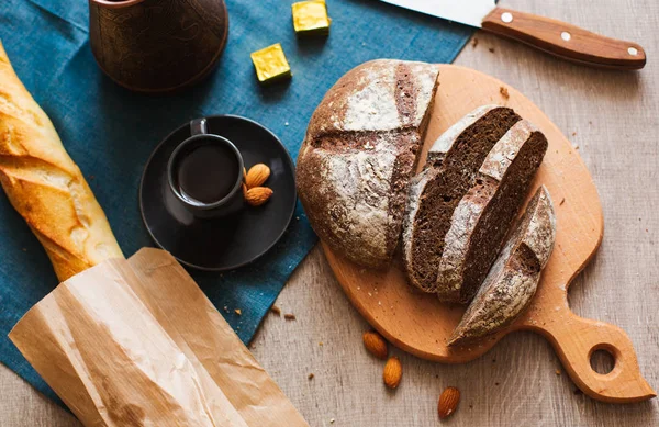 Taze ev yapımı koyu ahşap tahta ve kahve fincan dilimlenmiş beyaz un ile ekmek. Yakın çekim. Üstten görünüm.