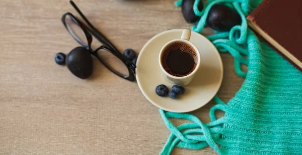 Cup of Aromatic Coffee and a Warm plaid on a Wooden Background. Autumn Theme