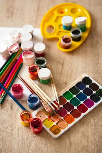 Watercolor Pallet, Oil Paints, Brushes Set and Wooden Color Pencils for Painting,  on Wooden background, Close up