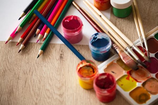 Watercolor Pallet, Oil Paints, Brushes Set and Wooden Color Pencils for Painting,  on Wooden background, Close up