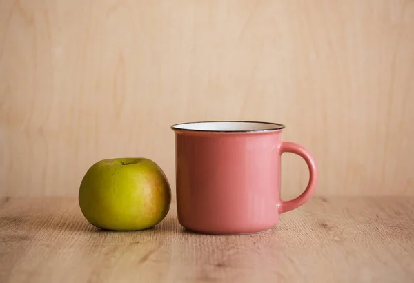 Pink Mug and Apple on a Wooden  Background, Perfect for Back to School and Teachers or Breakfast and Cafe. Copy Space