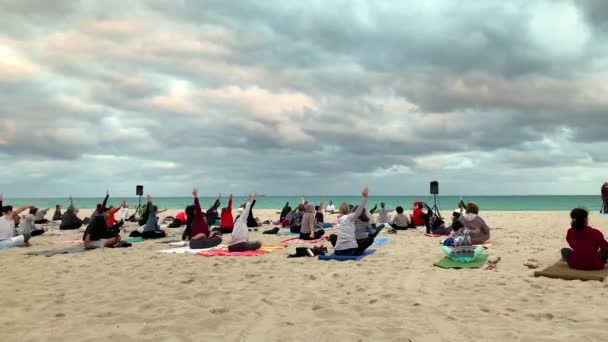 Miami, Fl, Usa – 20. ledna 2019: Group jógy na písečné pláži při západu slunce. Skupina lidí cvičí jógu na pláži. Úplněk v Miami