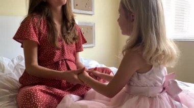 Genç hamile anne oynarken onun küçük komik kızı süre oturan bir kanepe ile