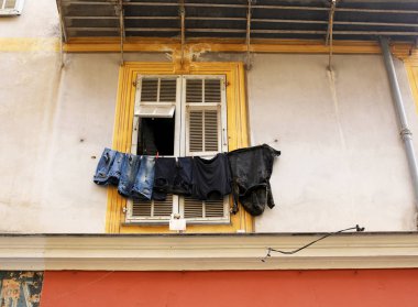 Sarı pencere ve çamaşır kurutma ile eski bir evin duvarına,