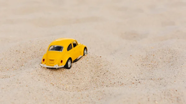 Gelber Kleinwagen auf Sandhintergrund — Stockfoto