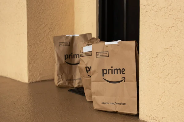 Paquetes de Amazon en la puerta del apartamento.Amazon es el minorista más grande del mundo . — Foto de Stock