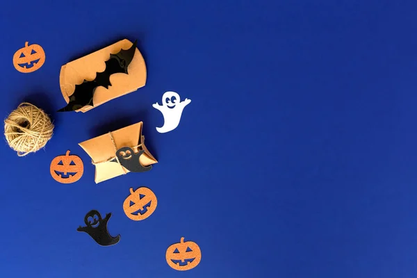 Halloween  Decorations, Craft Packages, rope, paper pumpkin, ghost on a Blue background. Handmade gift on blue background.