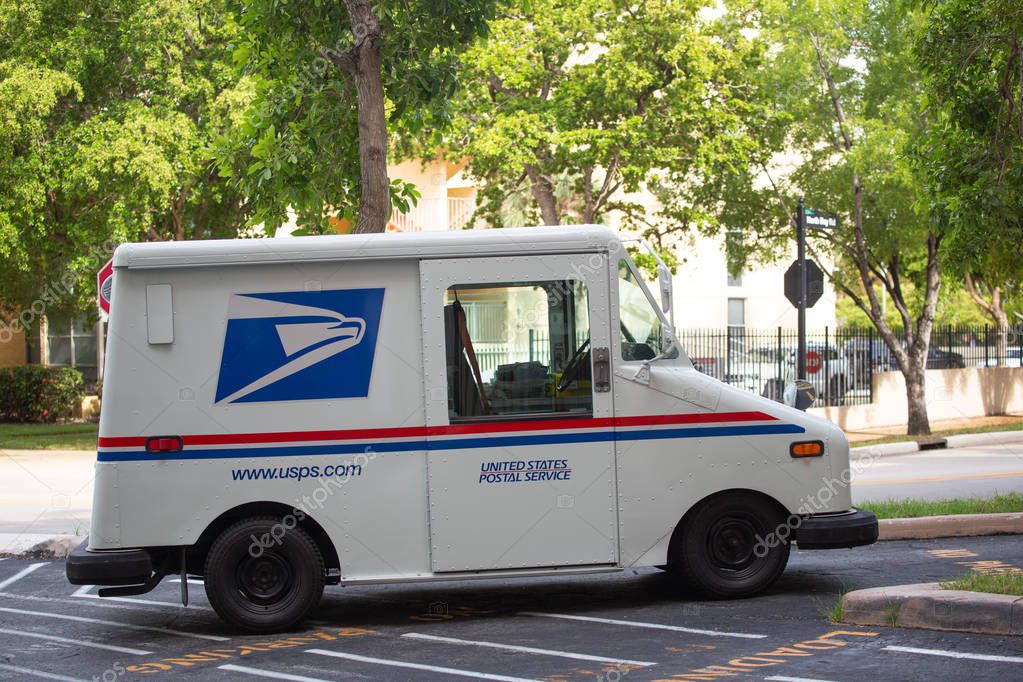 Miami, USA - August 6 2019: USPS car parked at the building, Sunny Isles Beach, Florida. USPS provides is a shipping and mailing service in the United States