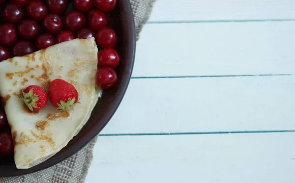 Healthy food background, pancakes, cherry, strawberry on plate on wooden table