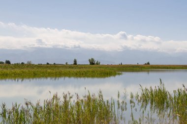 bulutlar dağlar arka planda bir göl ile manzara