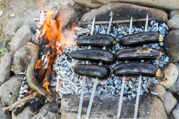 eggplants on skewers cooked on charcoal fire
