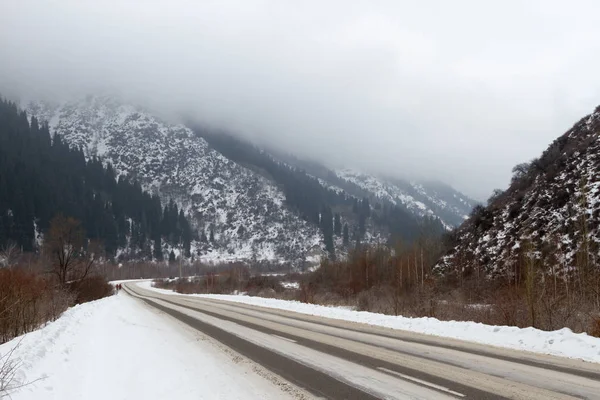 Yoğun kar yağmadan önce Almaty Gölü 'ne giden kış yolu.