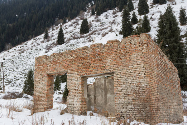 заброшенное старое кирпичное здание в горах без крыши
