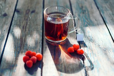 ahşap bir masa üzerinde sağlık için sağlıklı çay ile olgun ahududu taze demlenmiş