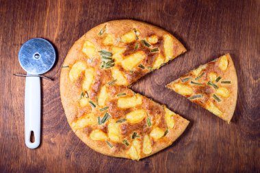 peynirli pizza yuvarlak. bir parça ile bir bıçakla kesilmiş. ahşap arka plan