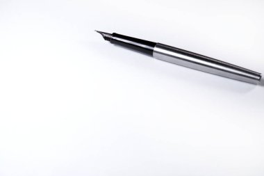 On a blank sheet of paper lies an ink handle metal