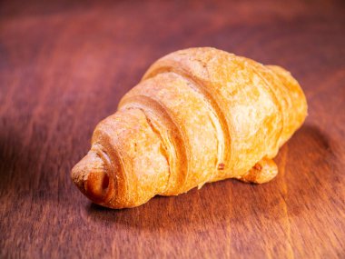 Taze kruvasan Kiraz ahşap bir masaya bırakır. rulo 