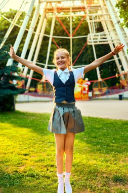kız öğrenci neşeli gülümseyerek ve ellerini kaldırarak atlama.