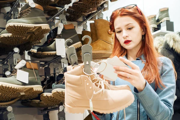 Chica en la tienda elige zapatos de invierno —  Fotos de Stock