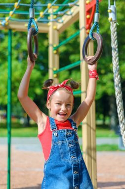 Küçük kız oyun bahçesinde oynuyor. 