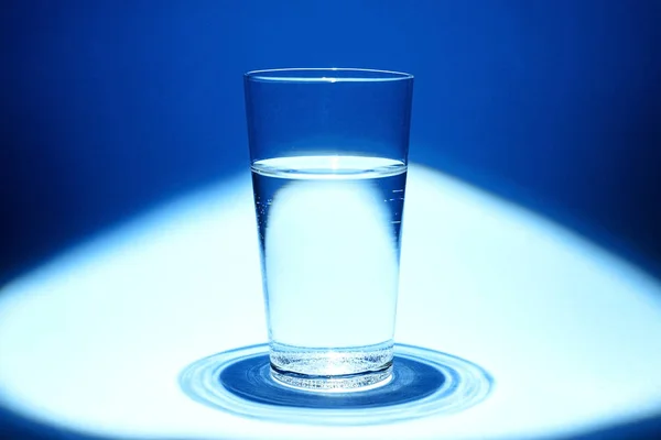 Glass of clean water on a blue background — Stock Photo, Image