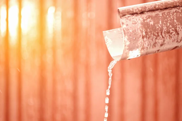 Wasser fließt durch das Abflussrohr. Der Schnee schmilzt. Der Frühling kam — Stockfoto