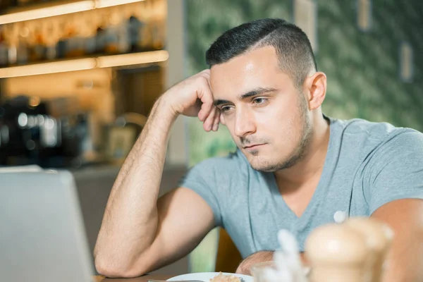 iş yerinde bir kafede üzgün genç adam. Adam yorgun. Freelancer. 