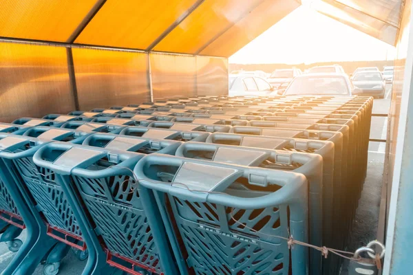 empty grocery carts stand in the parking lot near the supermarket