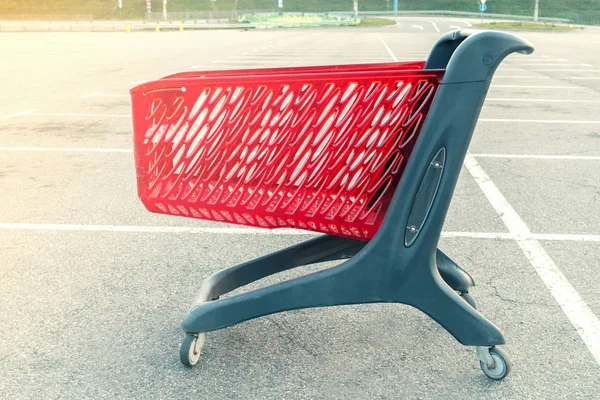 lonely grocery cart stands in an empty parking lot