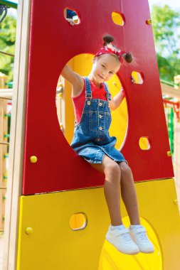 Küçük kız oyun bahçesinde oynuyor. 