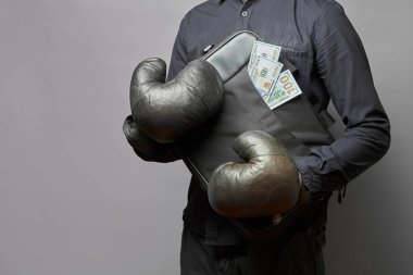 Gömlekli ve deri eldivenli bir adam içinde para olan bir çanta tutuyor. iş koruma kavramı