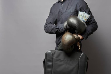 Boks eldivenli iş adamı elinde bir çanta ve para tutuyor. iş güvenliği kavramı