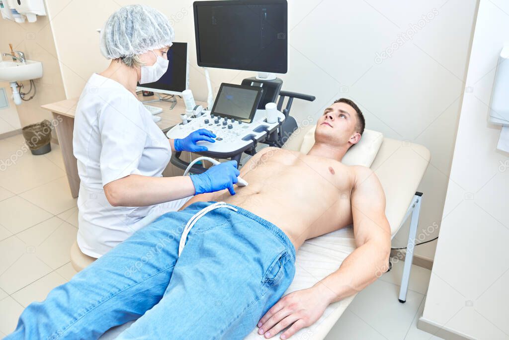 ultrasound of the abdomen in a man. doctor works on ultrasound equipment