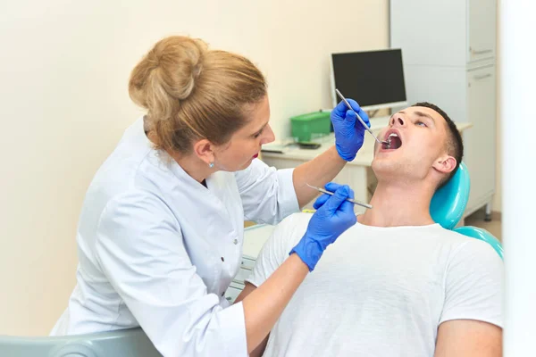 Dentista Mulher Examina Boca Homem Uma Recepção Escritório — Fotografia de Stock