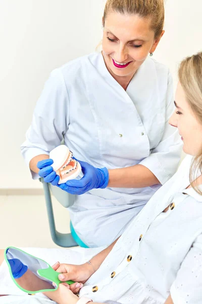 Zubní Lékař Ukazující Falešné Zuby Trpělivé Ženě — Stock fotografie