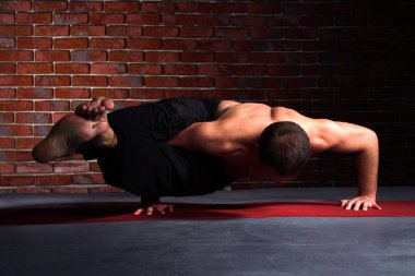 Yoga ashtavakrasana poz yapan erkek
