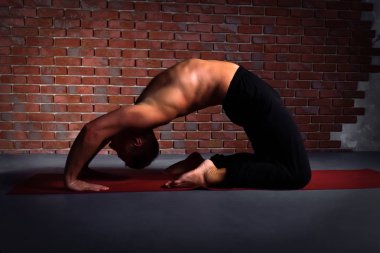  Yoga Kapotasana poz yapan genç erkek