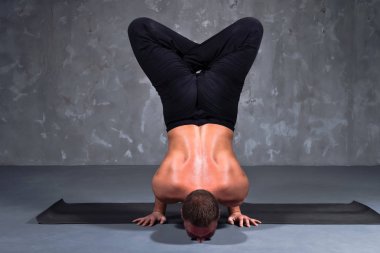 Adam yoga Urdhva padma vrikshasana poz gerçekleştirir